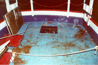 Photo 2 - Aft end of main deck showing intact steel bulwark and hatch opening in main deck with no sealing gasket or means of securing flush wooden cover